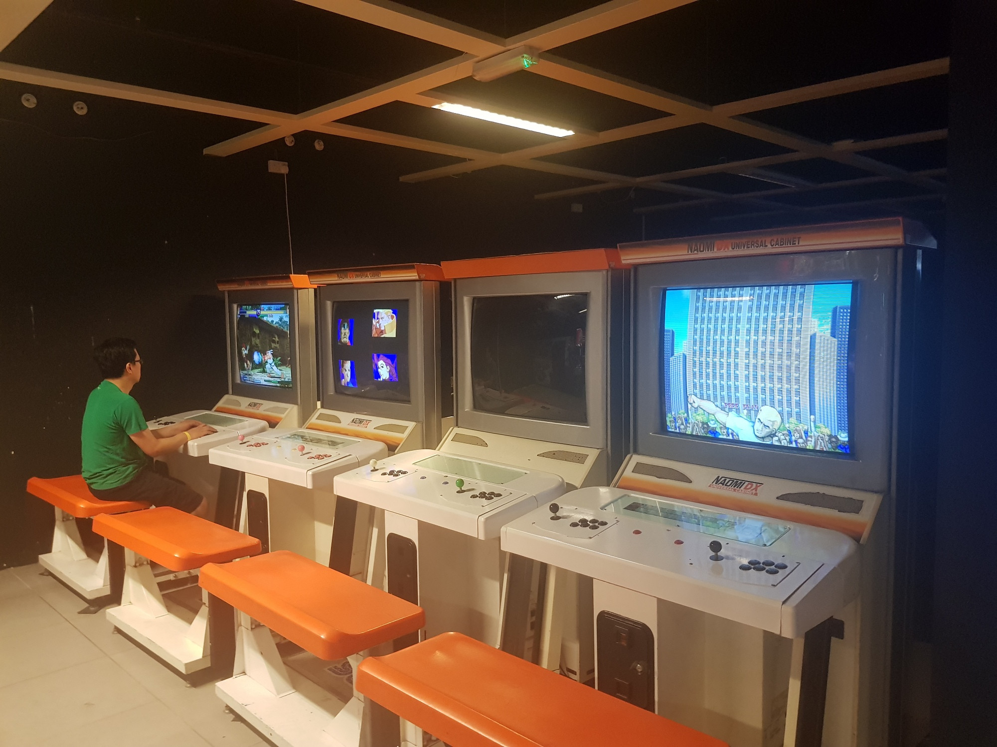 A row of fighting game cabinets: Street Fighter Zero 3, Street Fighter Alpha 2, Street Fighter EX2, and Street Fighter 2: Hyper Fighting